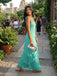 Front view of elegant emerald green chiffon maxi dress showcasing the soft V-neckline, self-tie shoulder straps, and fluid cascading ruffles in a luxurious European estate parlor.