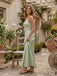 Woman in a light green dress standing in a garden setting