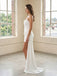 Woman in a strapless white dress standing in a room with large windows and brick walls.