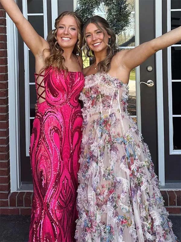 Two women in formal dresses standing outside a house.
