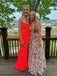 Two women in formal dresses standing on a wooden deck with a scenic background.