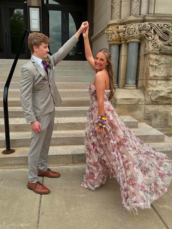 Two people in formal attire standing on steps outside a building.